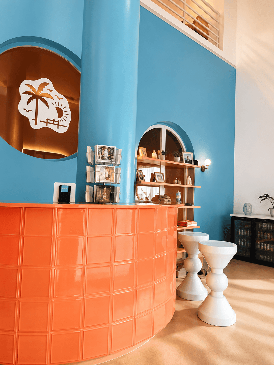 Studio Monday — mur bleu, réception terracotta, niche palmier